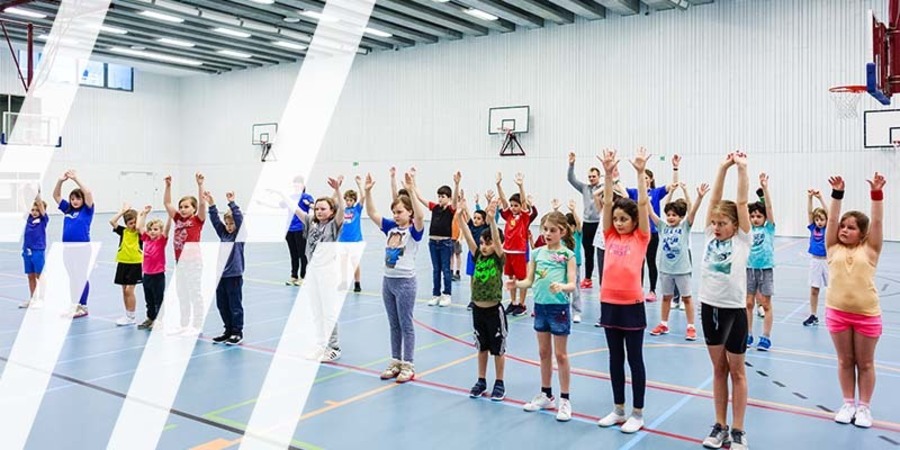 Kinderen dansen in sporthal Sint-Ludgardis